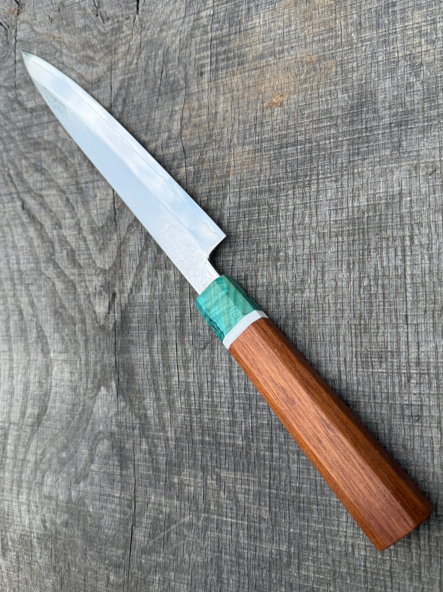 Knife with a wooden handle and turquoise accent on a wooden surface